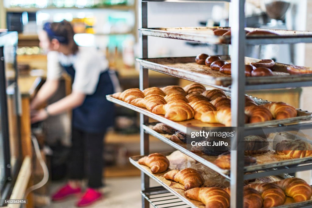 Fresh French Bread and croissants in a Bakery in cooling rack