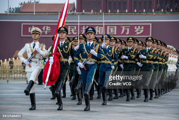 The Guard of Honor of the Chinese People's Liberation Army escorts the Chinese national flag during a flag-raising ceremony at Tian'anmen Square on...