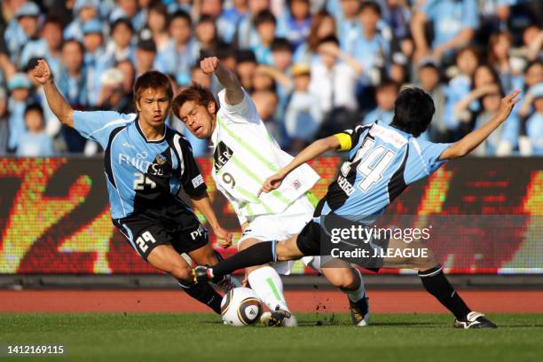 Yutaka Tahara of Shonan Bellmare controls the ball under pressure of Hiroyuki Taniguchi and Kengo Nakamura of Kawasaki Frontale during the J.League...