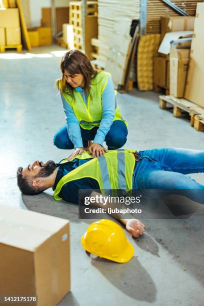 el trabajador del almacén hace rcp después del accidente - hot flush fotografías e imágenes de stock