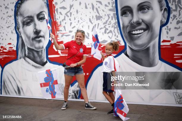 Fans of England pose for a photograph in front of a mural of Leah Williamson during the England Women's Team Celebration at Trafalgar Square on...