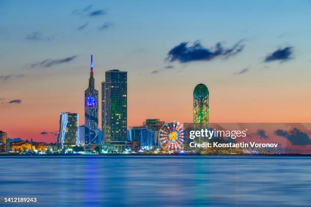 skyscrapers with city lights against the backdrop of sunset, at dusk - batumi stock-fotos und bilder