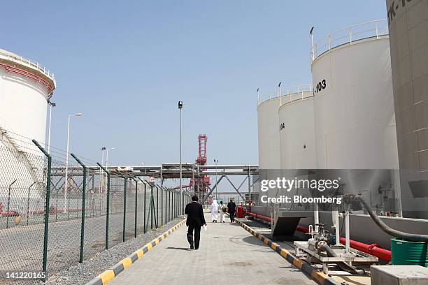 Visitors walk past oil tanks inside Fujairah port in Fujairah, United Arab Emirates, on Monday, March 12, 2012. ENOC, as Dubai's government-owned...