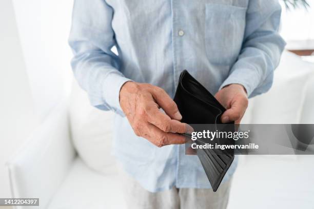 unrecognizable man holding empty wallet - debt collector stockfoto's en -beelden