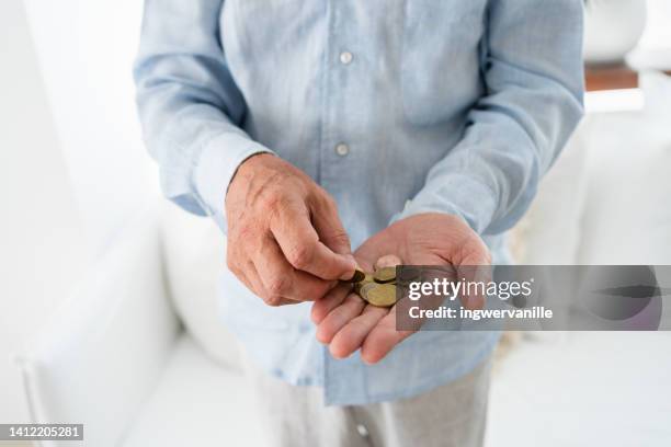 unrecognizable man counting euro coins in his hands - debt collector stock-fotos und bilder