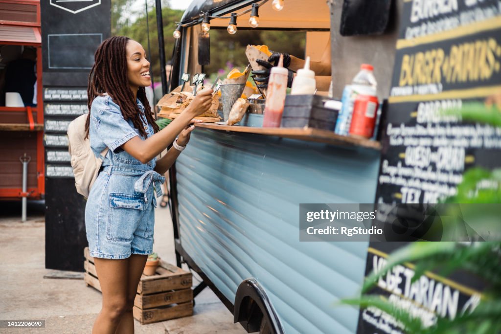 Afro girl buying potato at the fast food truck