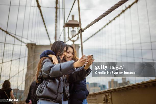 tourist selfie time at brooklyn bridge - chinese students stock pictures, royalty-free photos & images