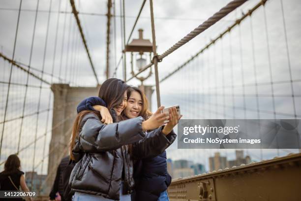 tourist selfie time at brooklyn bridge - new york trip bildbanksfoton och bilder