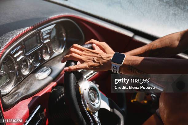 beautiful confidence woman steering boat wheel on sunny summer day - motorboot varen stockfoto's en -beelden