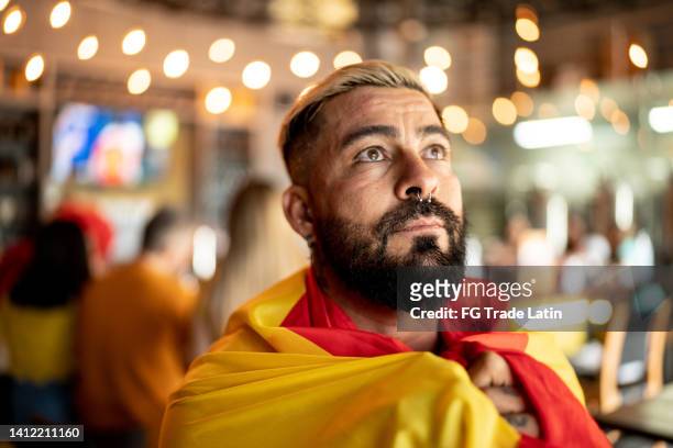 mid-adult-sportfan-mann, der sich ein spiel in einer bar ansieht - football for hope stock-fotos und bilder