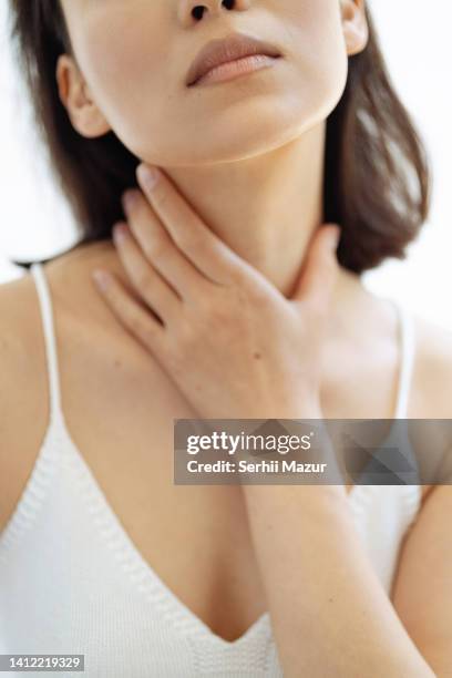 close up of woman touch her neck - stock photo - thyroid stock pictures, royalty-free photos & images