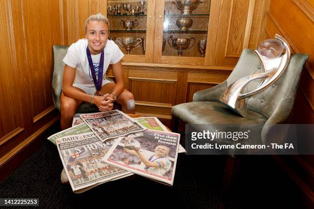 Leah Williamson of England poses for a photo as she reads a British newspaper while sitting next to the UEFA Women’s EURO 2022 Trophy prior to the...