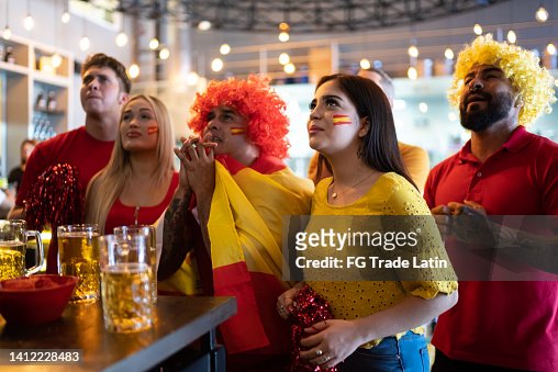 Spanish friends watching a soccer game at bar