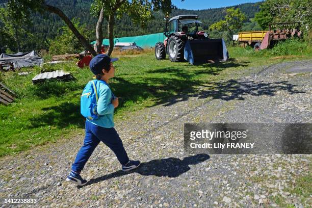 Enfant marchant sur un chemin à la campagne avec un sac à dos en Auvergne le 5 août 2020. MR.