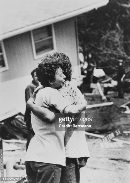 Pam Van Deusen hugs her son, Lon, after each finds out the other is alive after a flash flood struck the town killing 116 persons. There are 300...