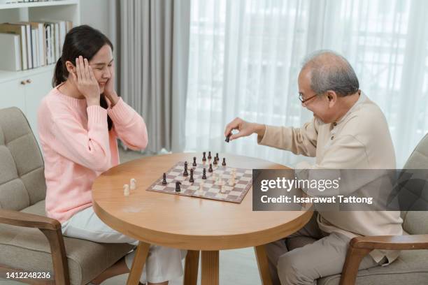 thoughtful father teaching his smart teenage daughter playing chess at home, famiily hobby, activity together on weekend. - kids playing chess stock pictures, royalty-free photos & images