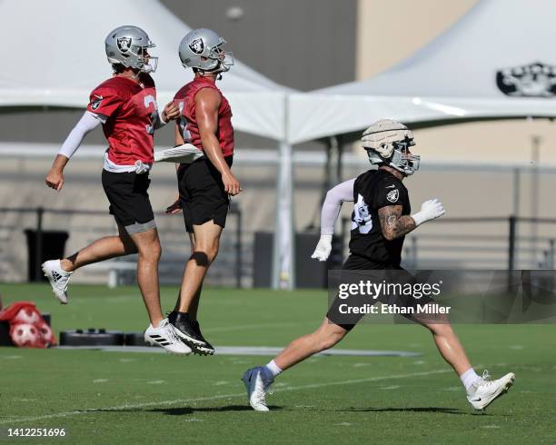 Quarterbacks Jarrett Stidham and Derek Carr and defensive end Maxx Crosby of the Las Vegas Raiders run on the field as they practice during training...