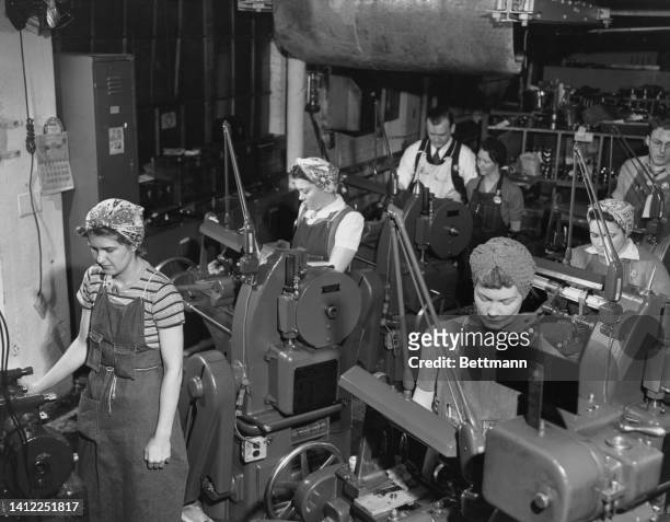 Women workers tend the gear cutting machines used in the Washington Navy Yard that lies on the outskirts of the nation's capital. This is one of the...
