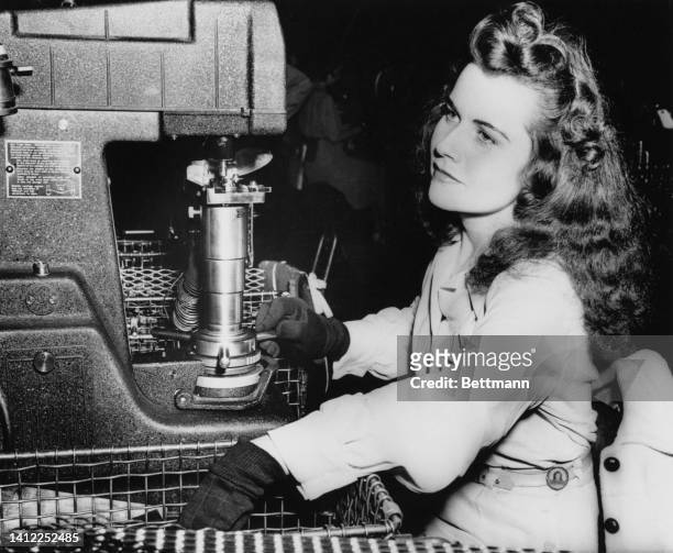 Dorothy operates her testing machine, which tests the hardness of roller-bearing cones. She works eight hours a day, six days a week, earning 60...
