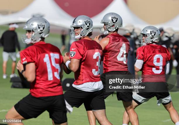 Quarterbacks Chase Garbers, Jarrett Stidham, Derek Carr and Nick Mullens of the Las Vegas Raiders drop back to pass during a drill at training camp...