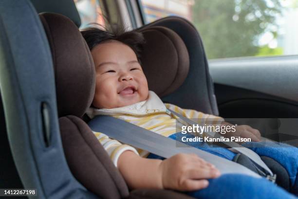 adorable little baby boy sitting in car seat. - safety harness stock pictures, royalty-free photos & images
