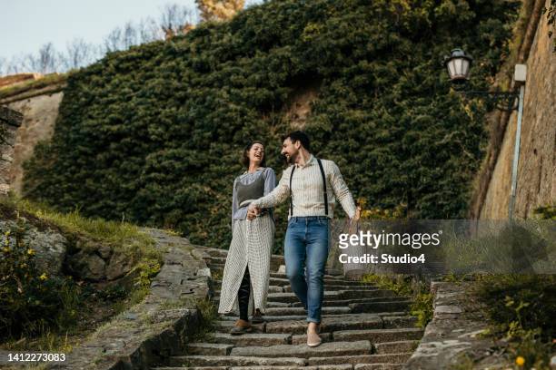 couple heureux profitant à l’automne à pied - castle square photos et images de collection