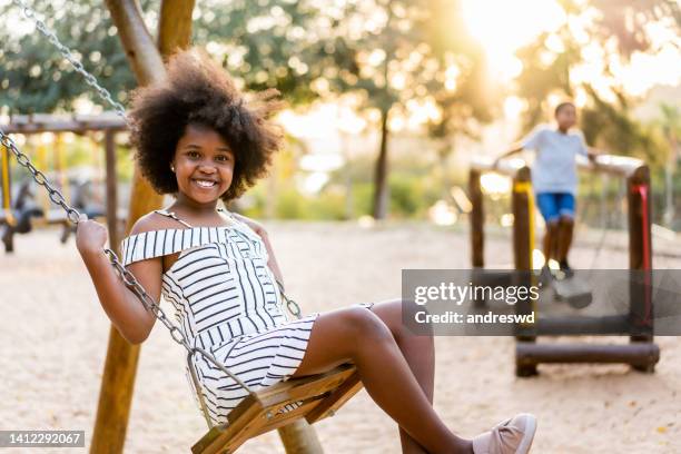 child girl swinging in the playground - 8 year old play stock pictures, royalty-free photos & images