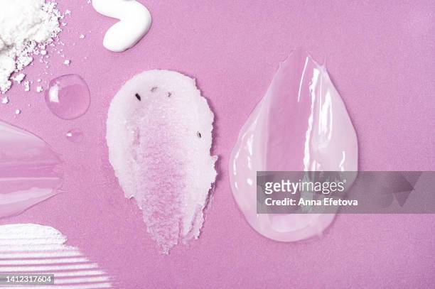 two cosmetic smears on pink background. sugar scrub with exfoliating particles and soothing aloe-based gel. beauty products with polyglutamic acid and beneficial oils. flat lay style - scrub texture photos et images de collection