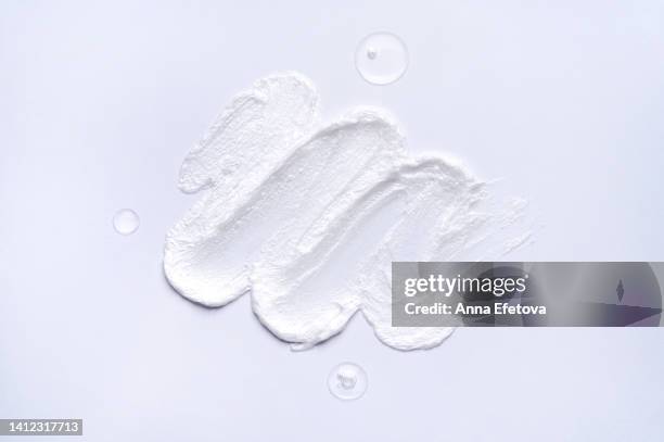 three drops of a tonic and textured white cream on white background. beauty products based on polyglutamic acid, ceramides and many vitamins. macrophotography from above - korean beauty products foto e immagini stock