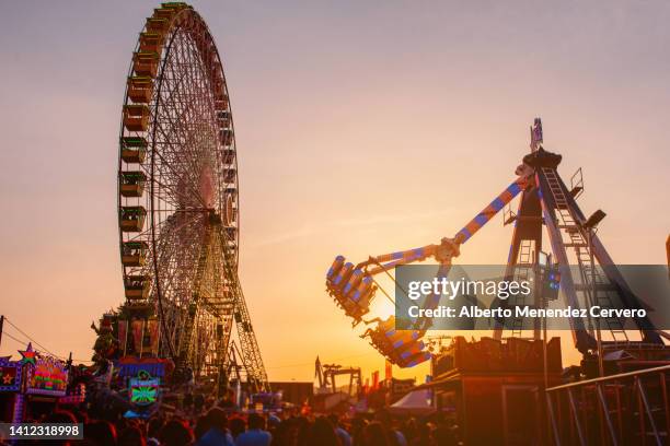 fairground rides at sunset - vergnügungspark stock-fotos und bilder