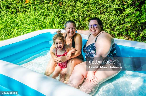 grandmother, aunt and baby girl playing in toy pool - childhood obesity stock pictures, royalty-free photos & images