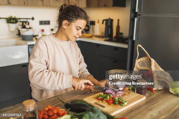 woman cutting fresh organic vegetables for salad on kitchen. sustainable lifestyle - glutenfrei stock-fotos und bilder