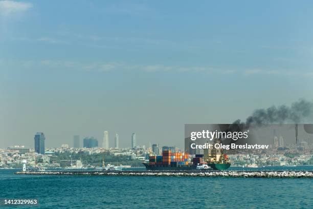 a huge merchant ship loaded with containers in the port of the big city. global trade and food crisis - bosphorus stock pictures, royalty-free photos & images