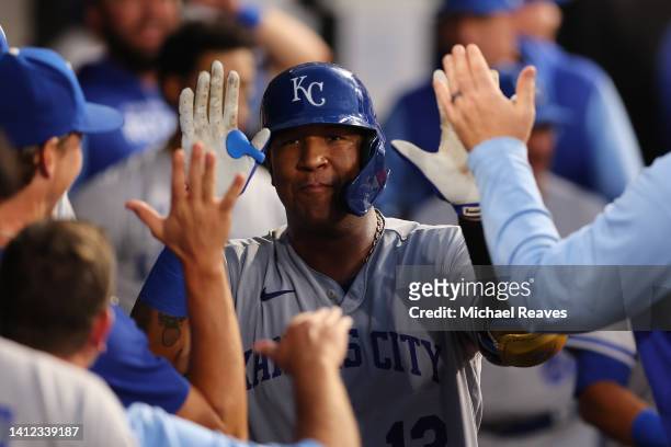 Salvador Perez of the Kansas City Royals high fives teammates after hitting a solo home run against the Chicago White Sox during the fourth inning at...