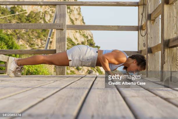 sporty young woman doing push-ups outdoors. outdoor sports concept - bodyweight training stock pictures, royalty-free photos & images