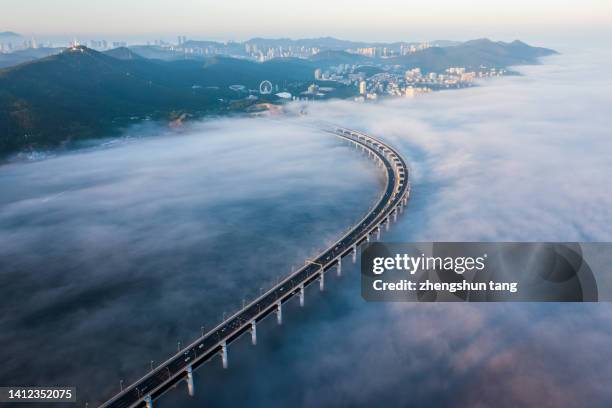 sea crossing bridge in fog. - dramatic sky road stock pictures, royalty-free photos & images