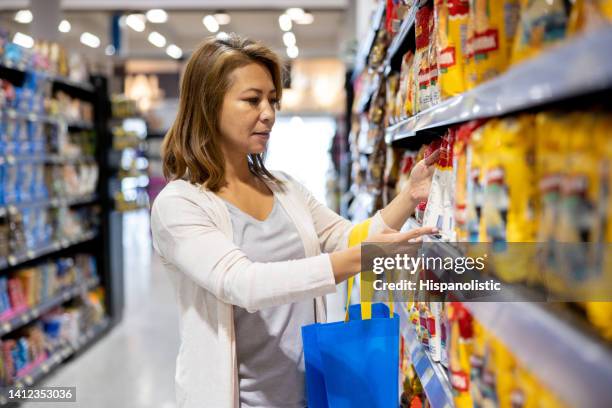 woman grocery shopping at the supermarket - flour bag stockfoto's en -beelden