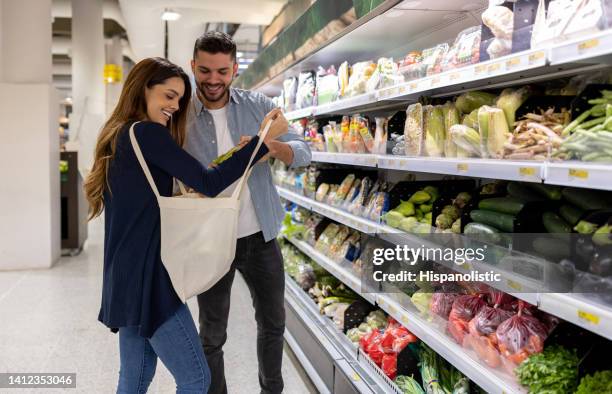 pareja comprando comestibles en el supermercado y usando una bolsa de mano - bolsa reutilizable fotografías e imágenes de stock