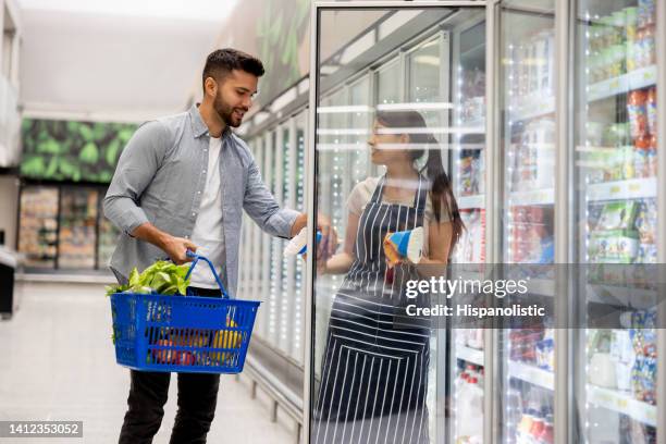 vendor helping a man shopping at the supermarket - supermarket refrigeration stock pictures, royalty-free photos & images