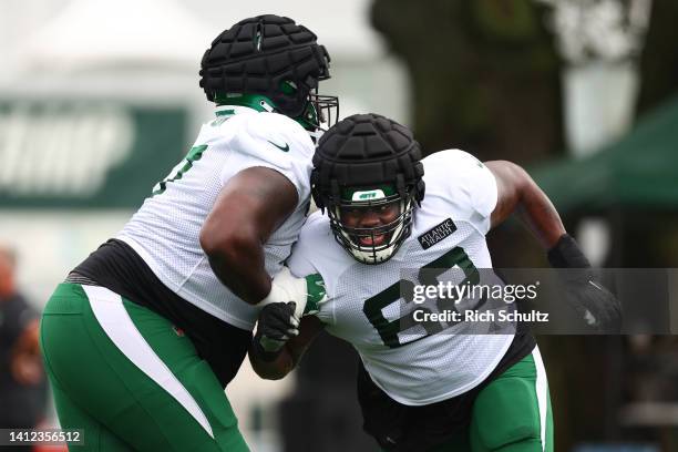 Offensive linemen Mekhi Becton and Derrick Kelly of the New York Jets battle each other during training camp at Atlantic Health Jets Training Center...