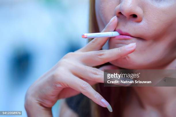 young woman enjoying a cigarette outdoors. - dinner jacket stock pictures, royalty-free photos & images