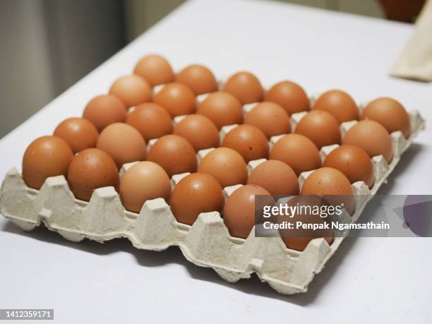 fresh eggs strack in carton of eggs brown paper - carton of eggs stock pictures, royalty-free photos & images