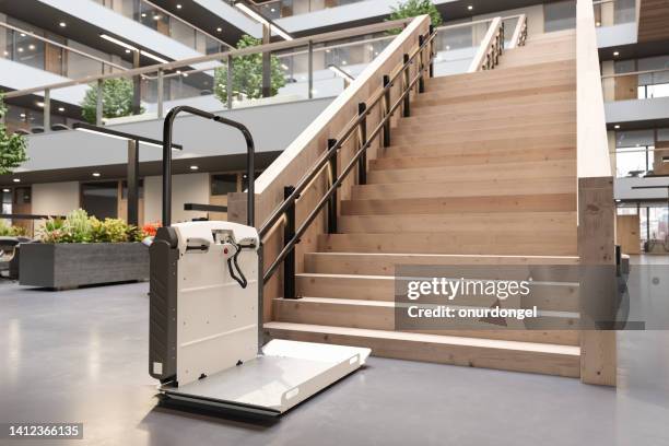 disability stair lift at office staircase for disabled people - rolstoelvriendelijk stockfoto's en -beelden