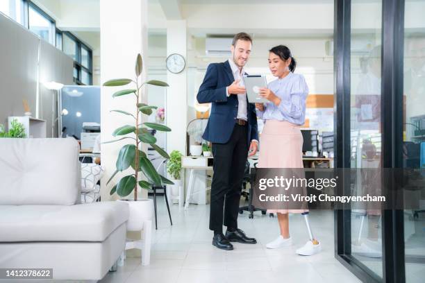 business colleagues in meeting with female amputee in office - accessibilité aux personnes handicapées photos et images de collection