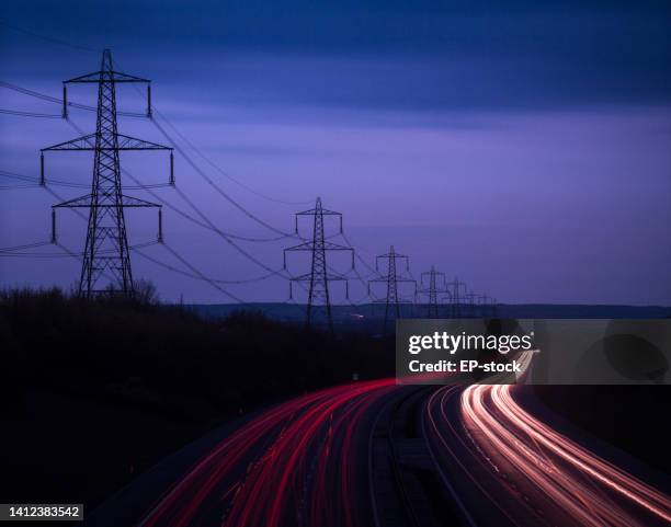 m40 motorway light trails and power cables at dusk, oxfordshire, england, united kingdom, europe - electricity pylon stock pictures, royalty-free photos & images