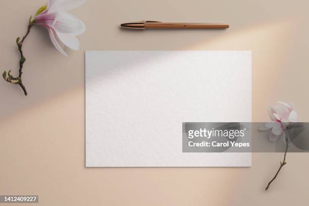 paper blank,template.neutral background with golden pen and white flowers - notepad white table foto e immagini stock