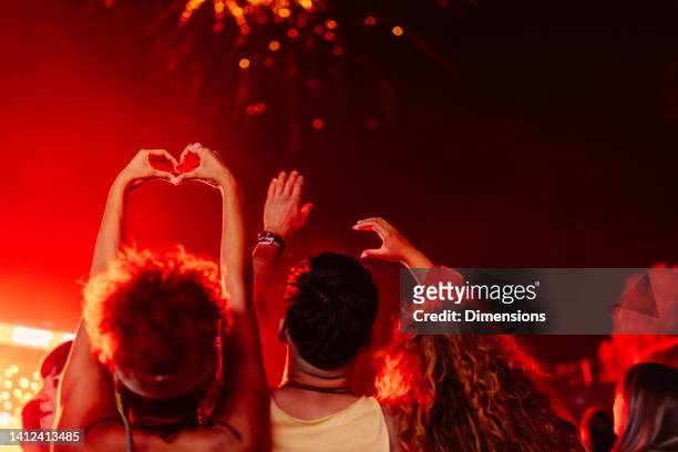 group of friends showing love at a concert - crowd hand heart stock pictures, royalty-free photos & images