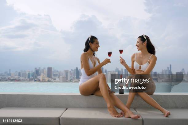 pretty women are wearing swimsuit and do activity at swimming pool. - rooftop pool stock pictures, royalty-free photos & images