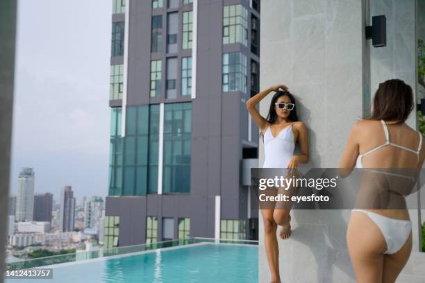 pretty women are wearing swimsuit and do activity at swimming pool. - center for asian american media stock pictures, royalty-free photos & images