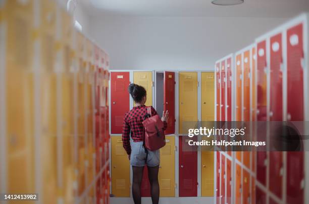 rear view of teenage girl in locker room. - locker foto e immagini stock